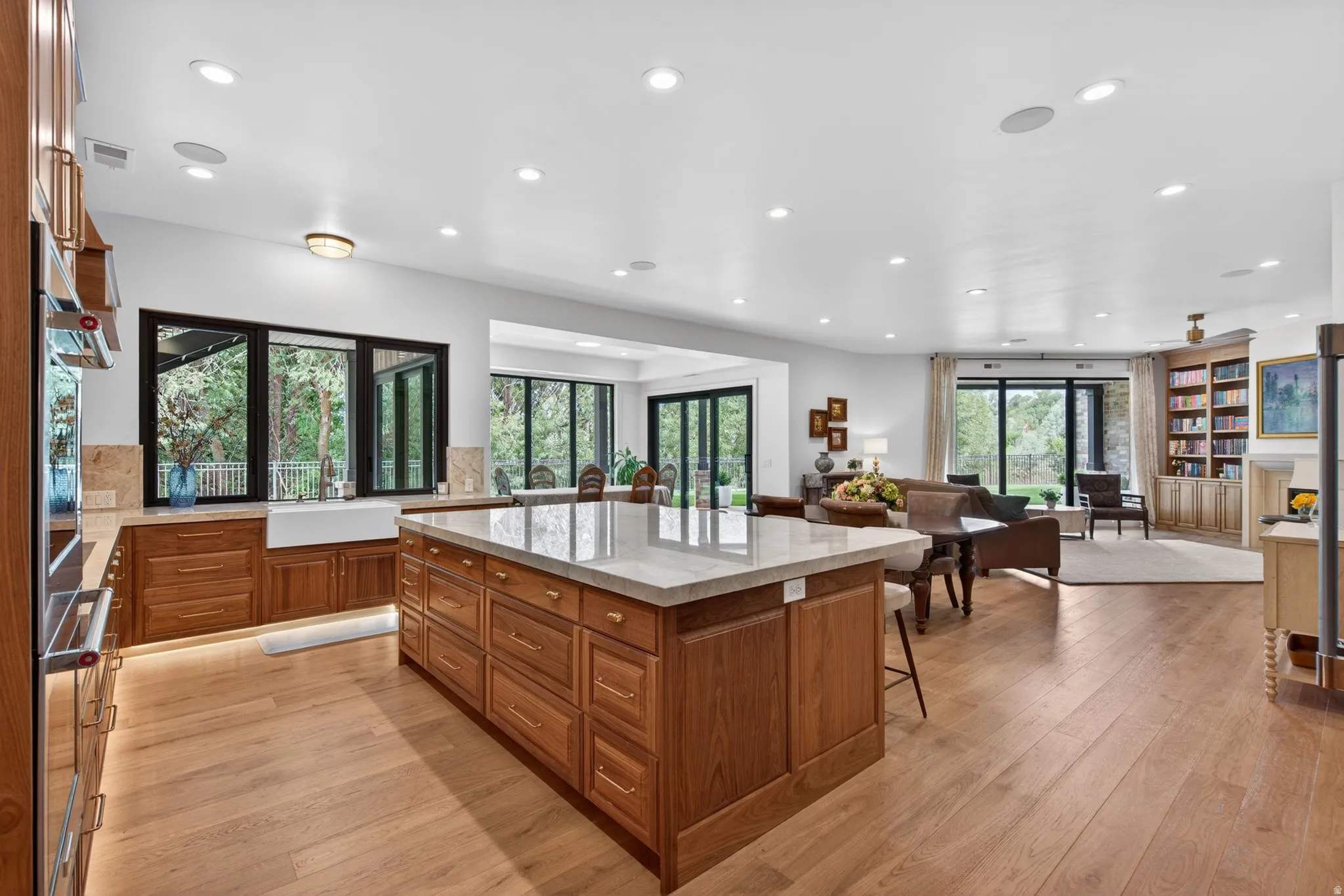 Open concept kitchen and living area featuring wood-finish flooring & walnut cabinets with quartzite counters