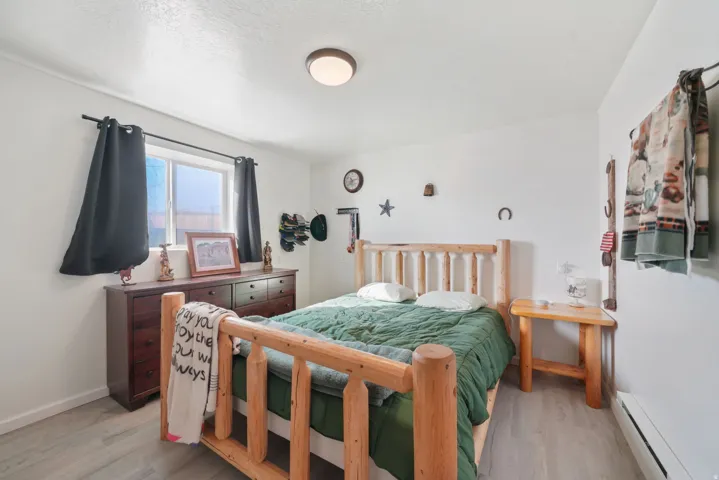 Bedroom with baseboard heating and light wood-style flooring
