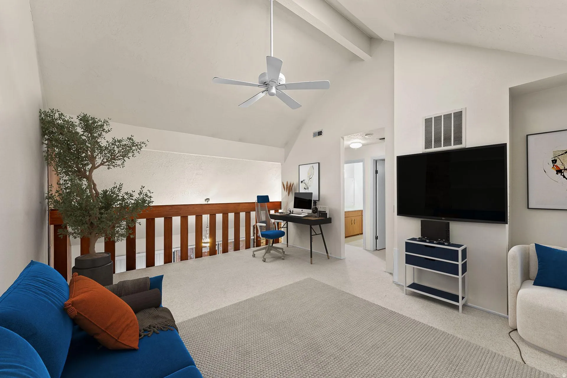 Living room with light colored carpet, a desk, and a ceiling fan
