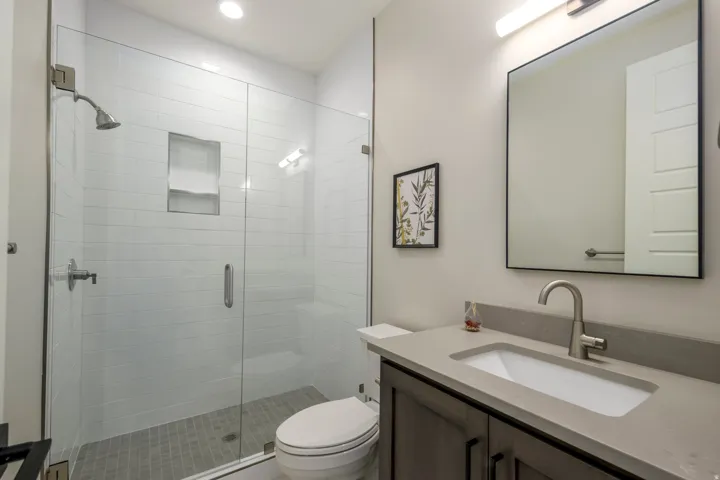 Bathroom with vanity, a shower stall, and recessed lighting