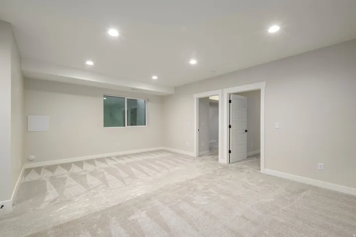 Finished below grade area featuring light carpet and recessed lighting