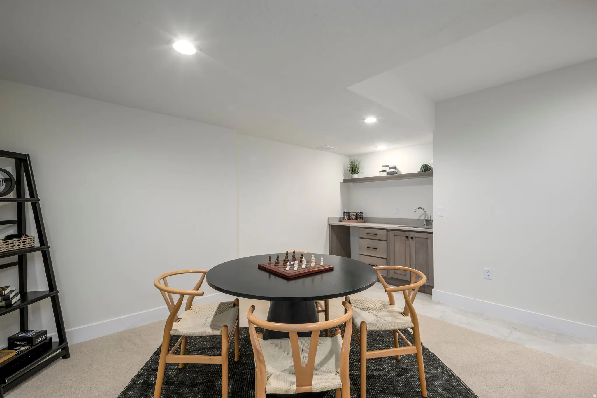 Dining room with recessed lighting, bar with sink, and light colored carpet