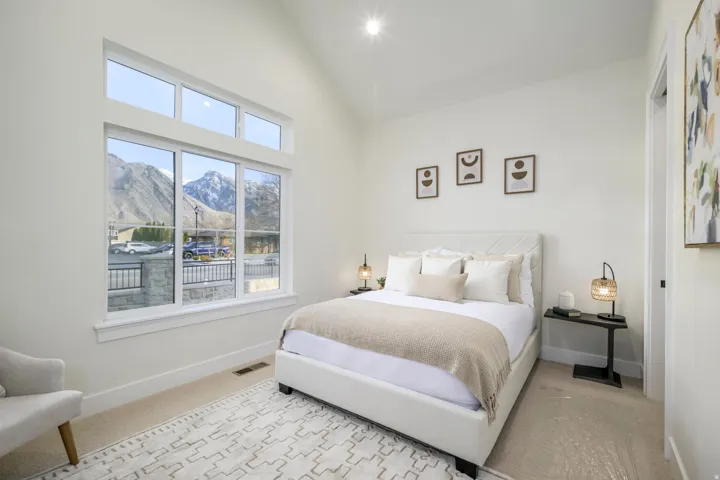 Bedroom with a mountain view, vaulted ceiling, light carpet, and recessed lighting