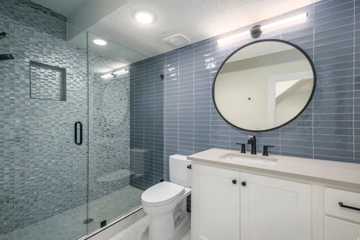 Full bathroom featuring tile walls, vanity, a shower stall, a textured ceiling, and decorative backsplash