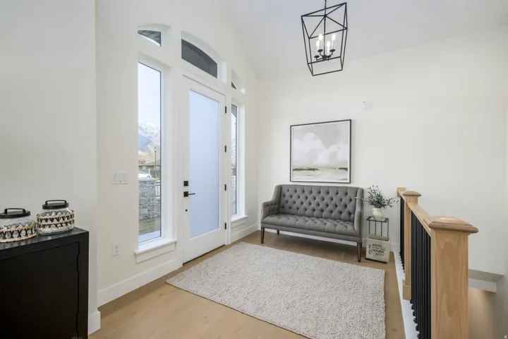 Foyer with vaulted ceiling, light wood-style floors, and suspended lighting