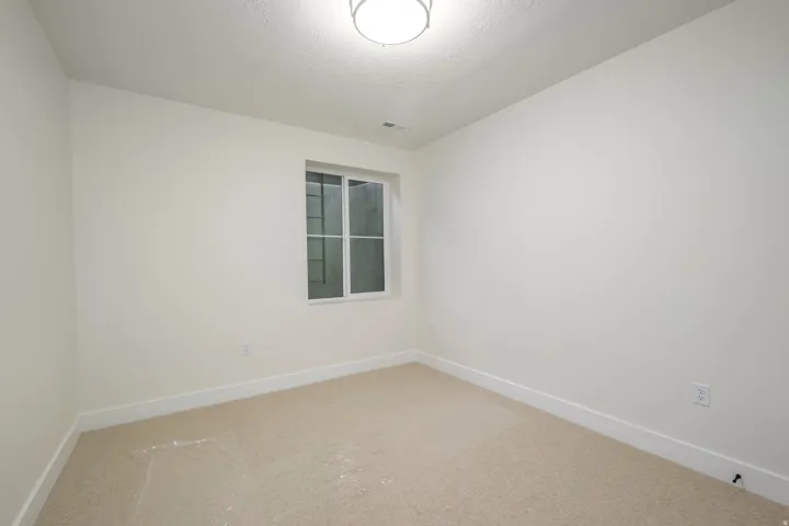 Carpeted spare room featuring baseboards
