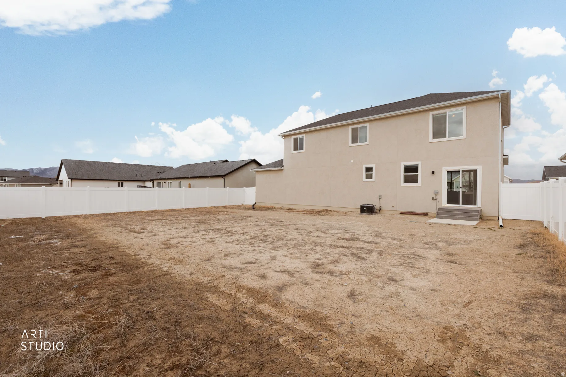 Back of house with a fenced backyard and stucco siding