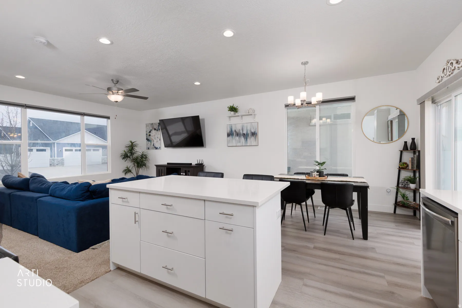 Kitchen featuring light countertops, open floor plan, dishwasher, and light wood finished floors