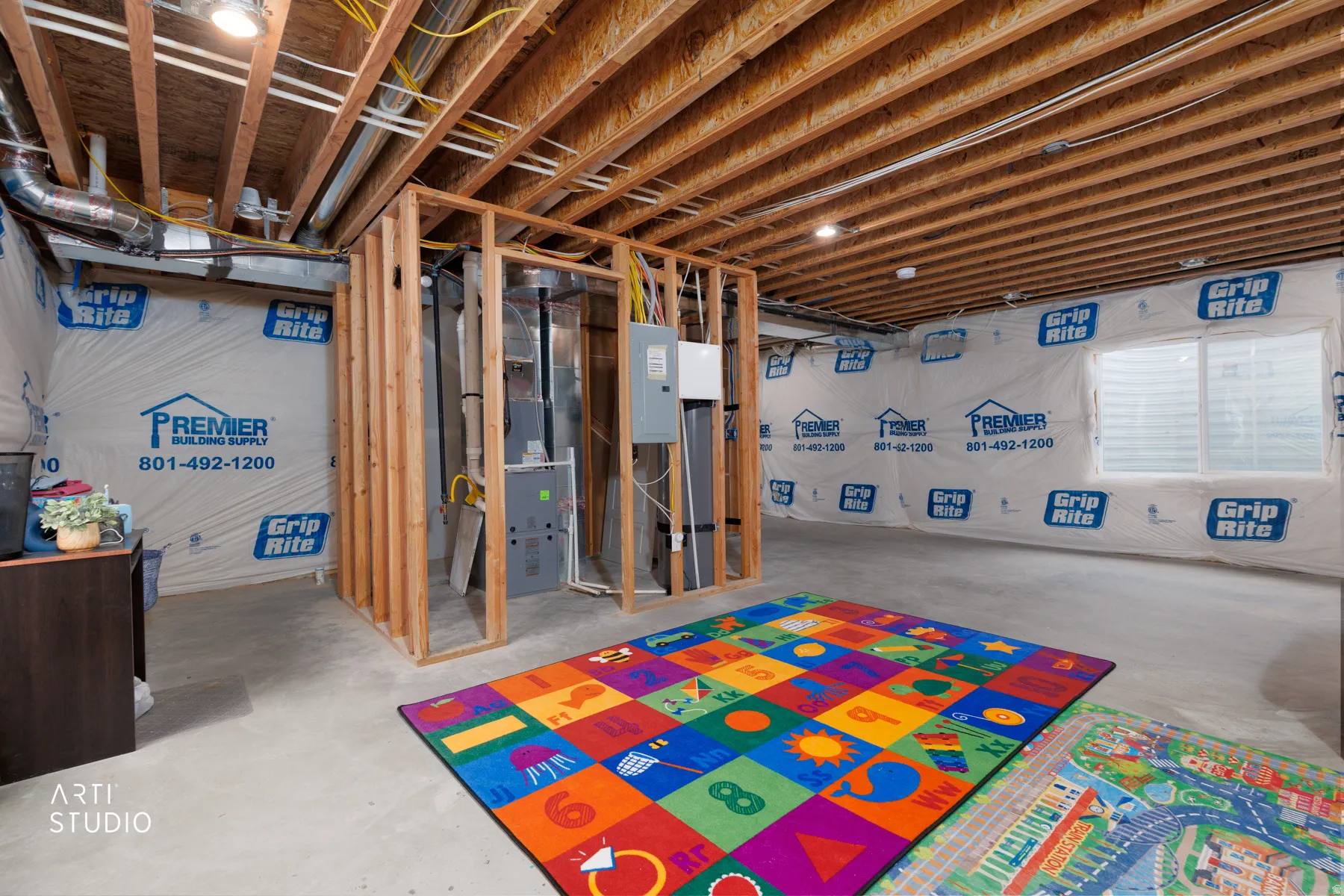 Unfinished basement featuring heating unit and electric panel