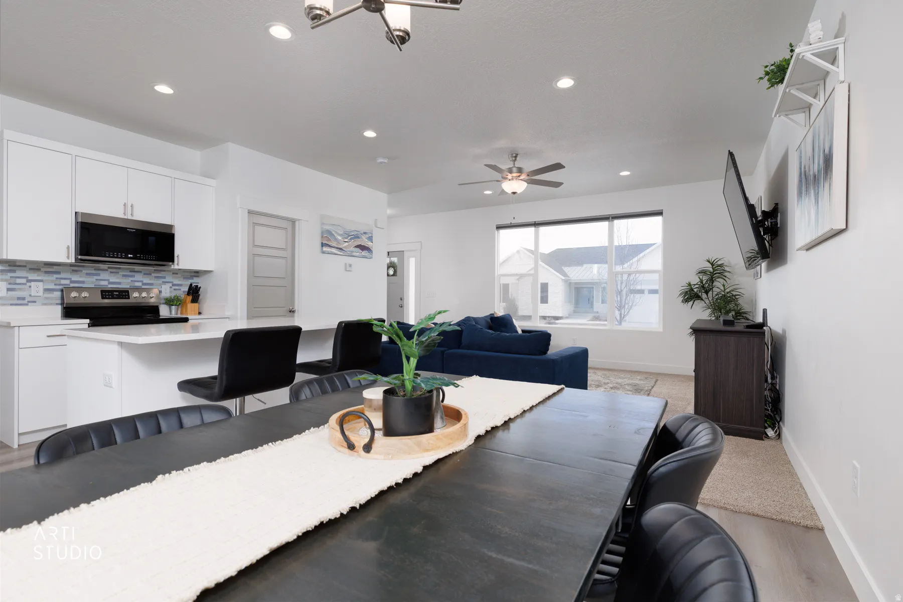 Dining area with light wood-style flooring, a ceiling fan, and hanging lights