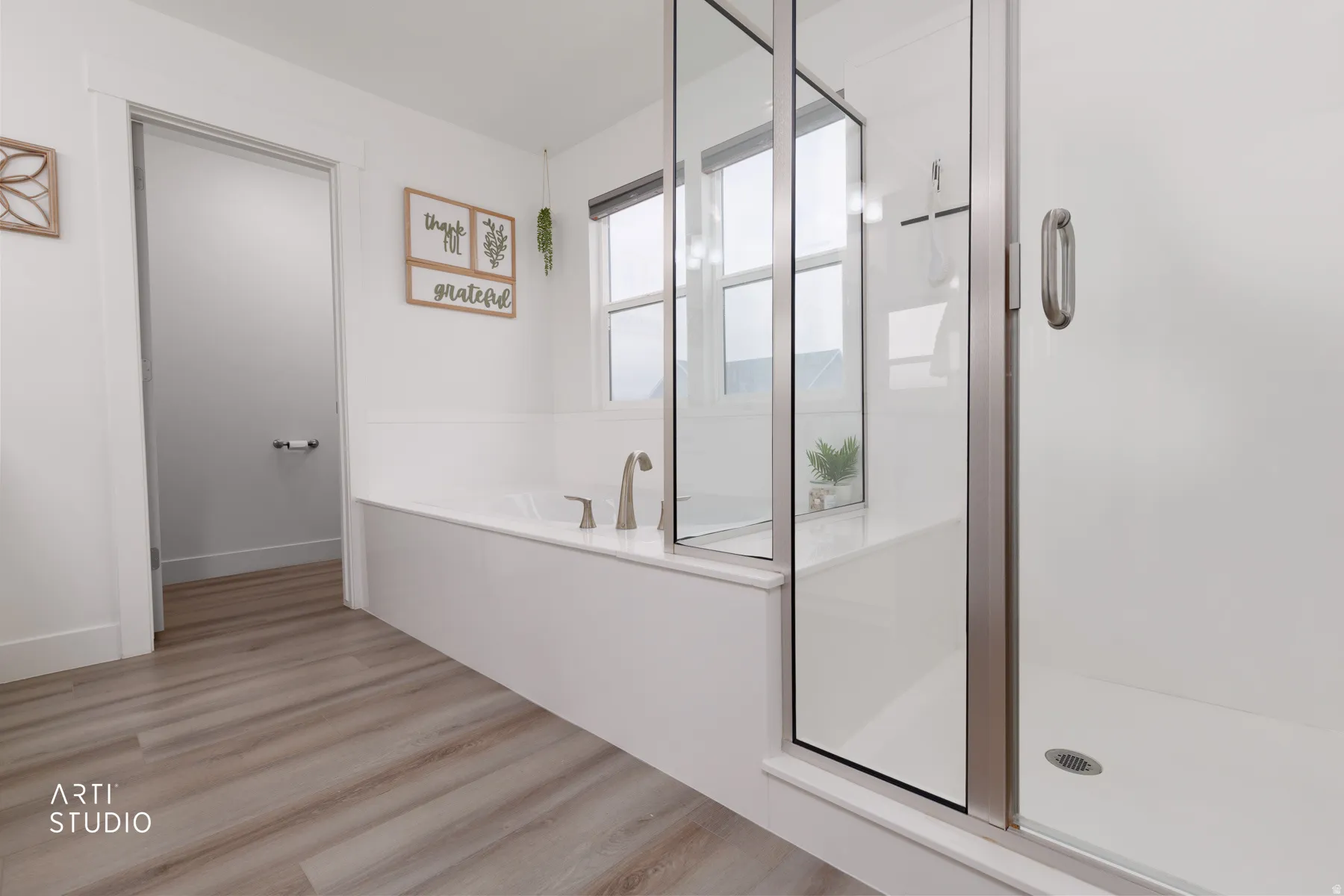 Bathroom with a bath, light wood finished floors, and a stall shower