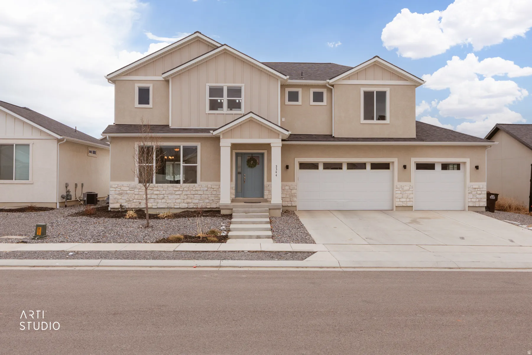 View of front of property with stone siding, concrete driveway, board and batten siding, and stucco siding