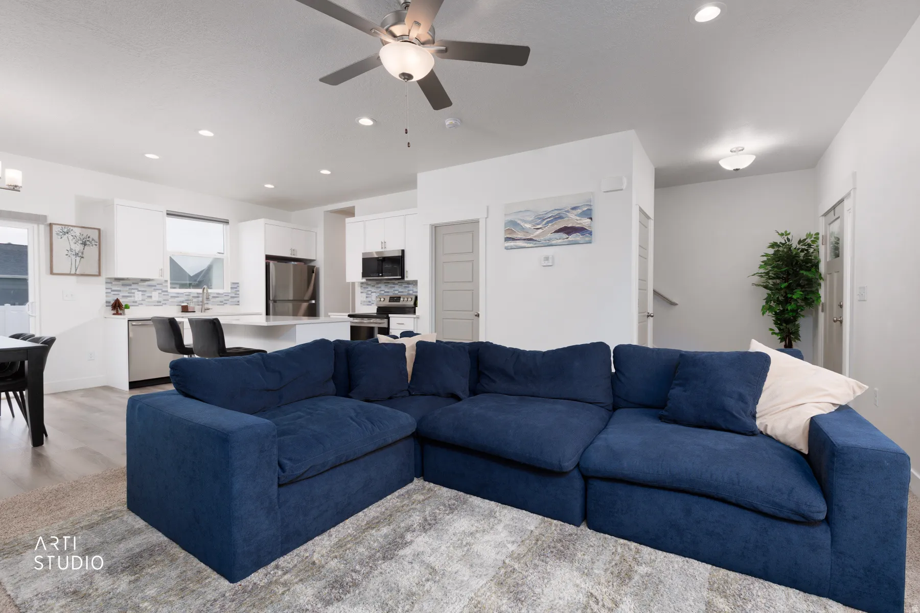 Living area with a ceiling fan, recessed lighting, and light wood-style flooring