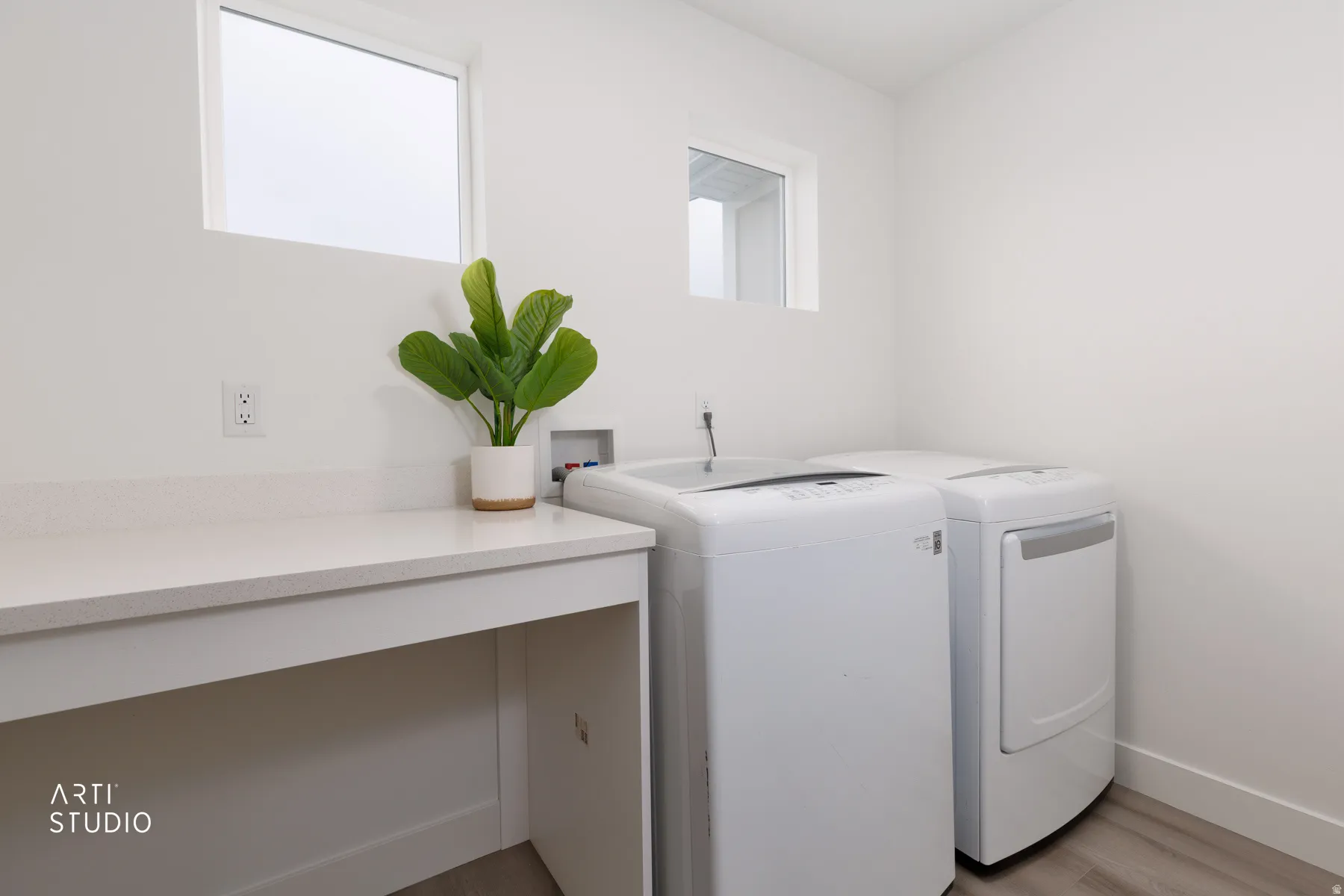 Laundry area featuring washer and clothes dryer and light wood-style floors
