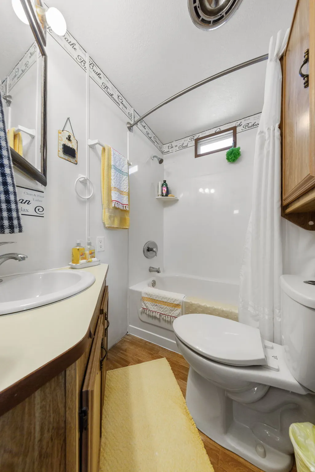 Bathroom with vanity, shower / tub combo, and light wood finished floors