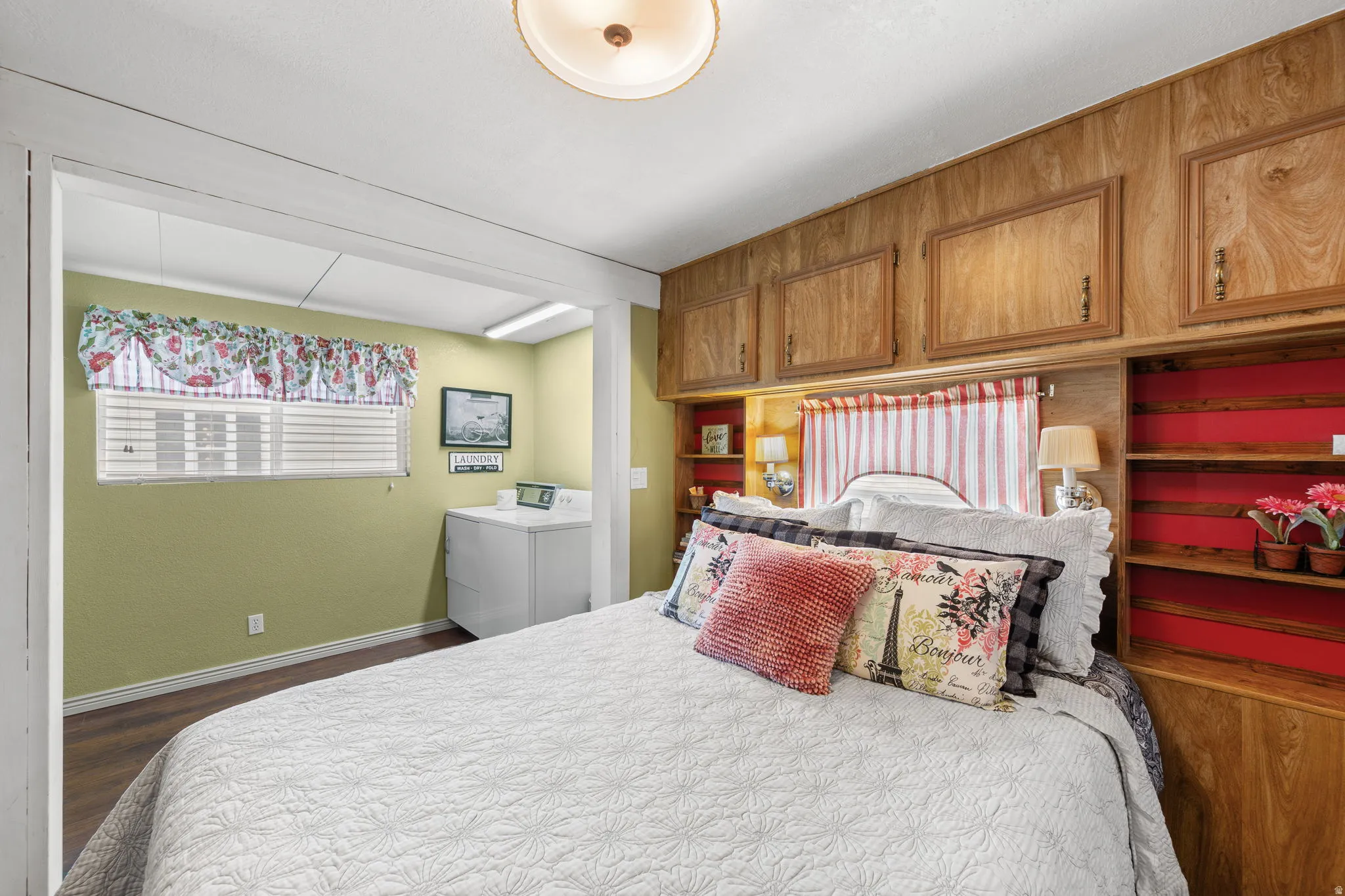 Bedroom with washer / clothes dryer and dark wood-type flooring