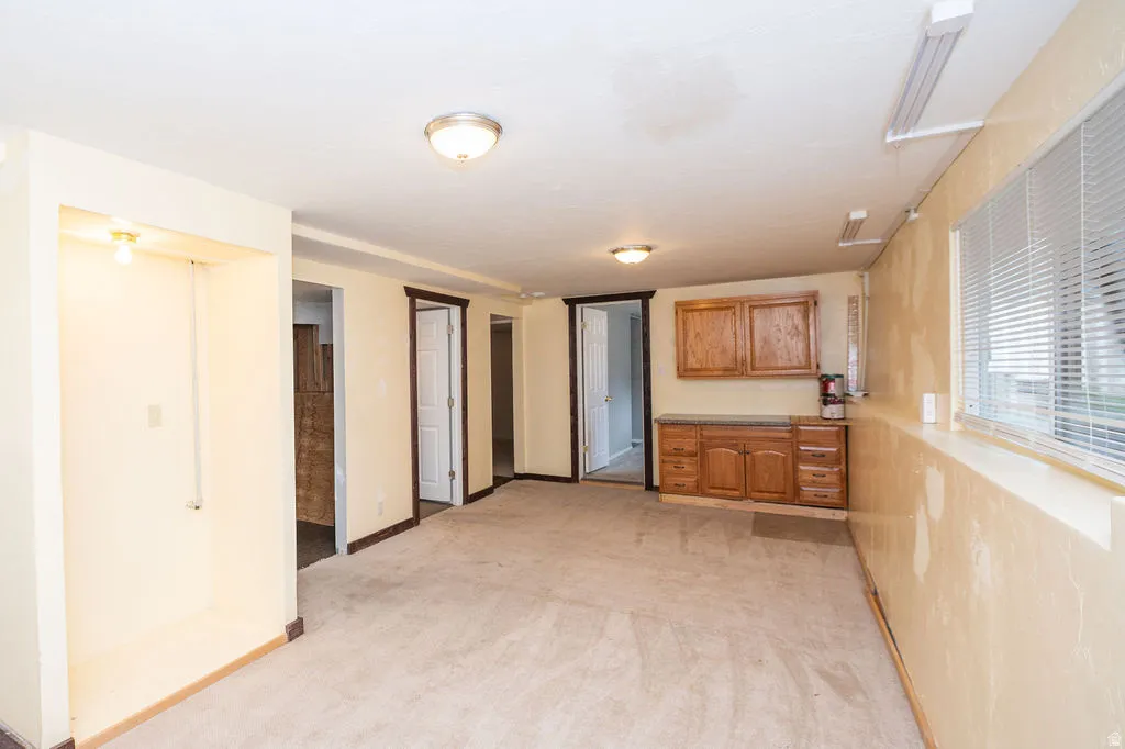 Kitchen featuring light carpet, wood finish cabinetry, and light countertops