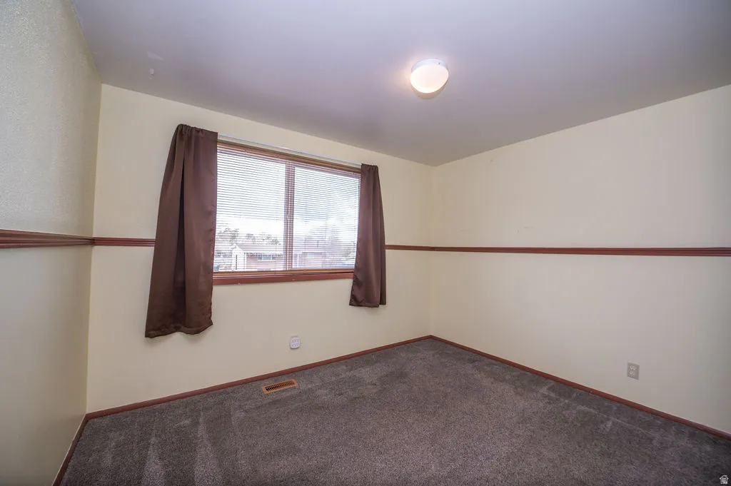 Carpeted empty room featuring baseboards