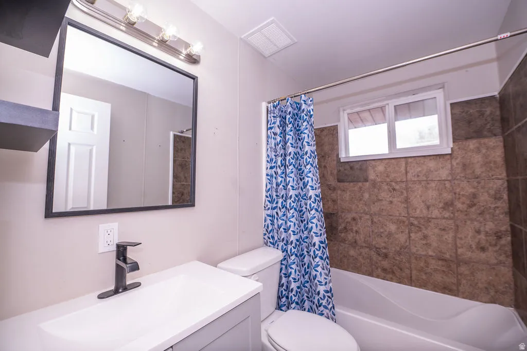 Full bath featuring vanity and shower / bathtub combination with curtain