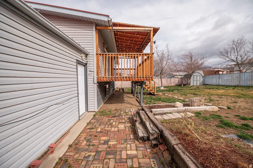 View of home's exterior with a storage shed and stairway