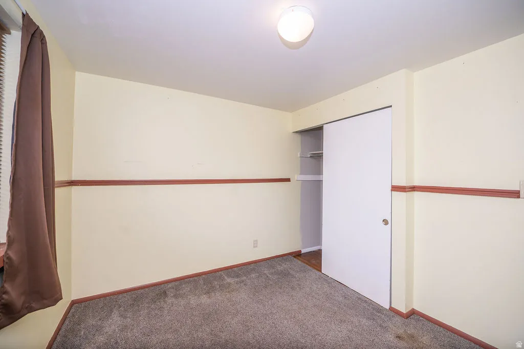 Unfurnished bedroom featuring carpet floors and a closet