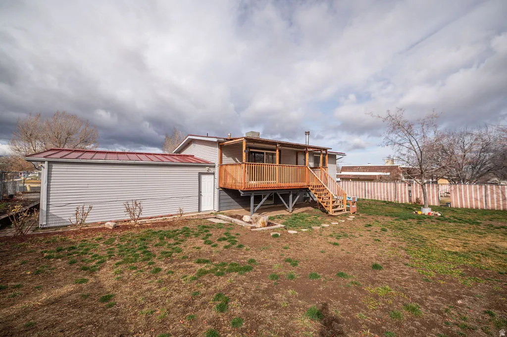Rear view of house featuring a wooden deck and a metal roof