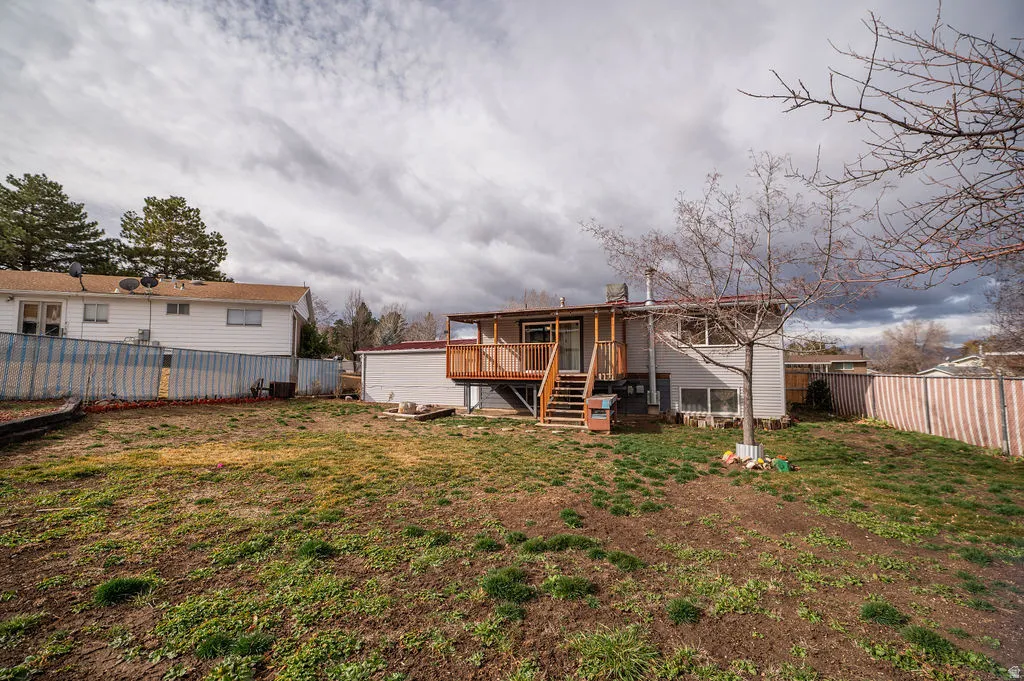 Rear view of property with a fenced backyard and a wooden deck