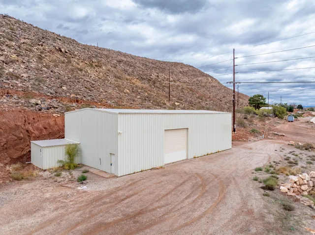 View of outbuilding with dirt driveway
