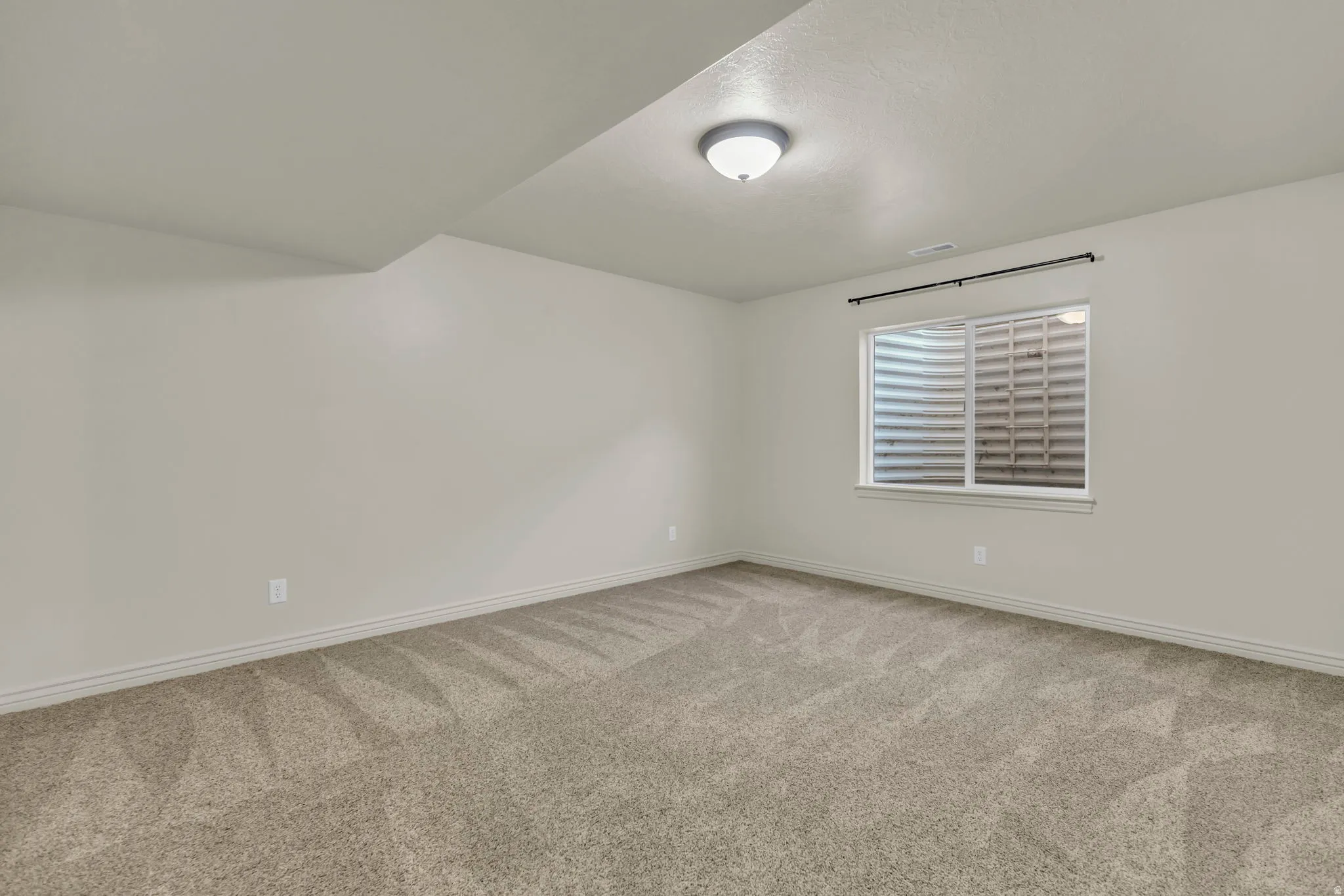 Unfurnished room with light carpet and baseboards