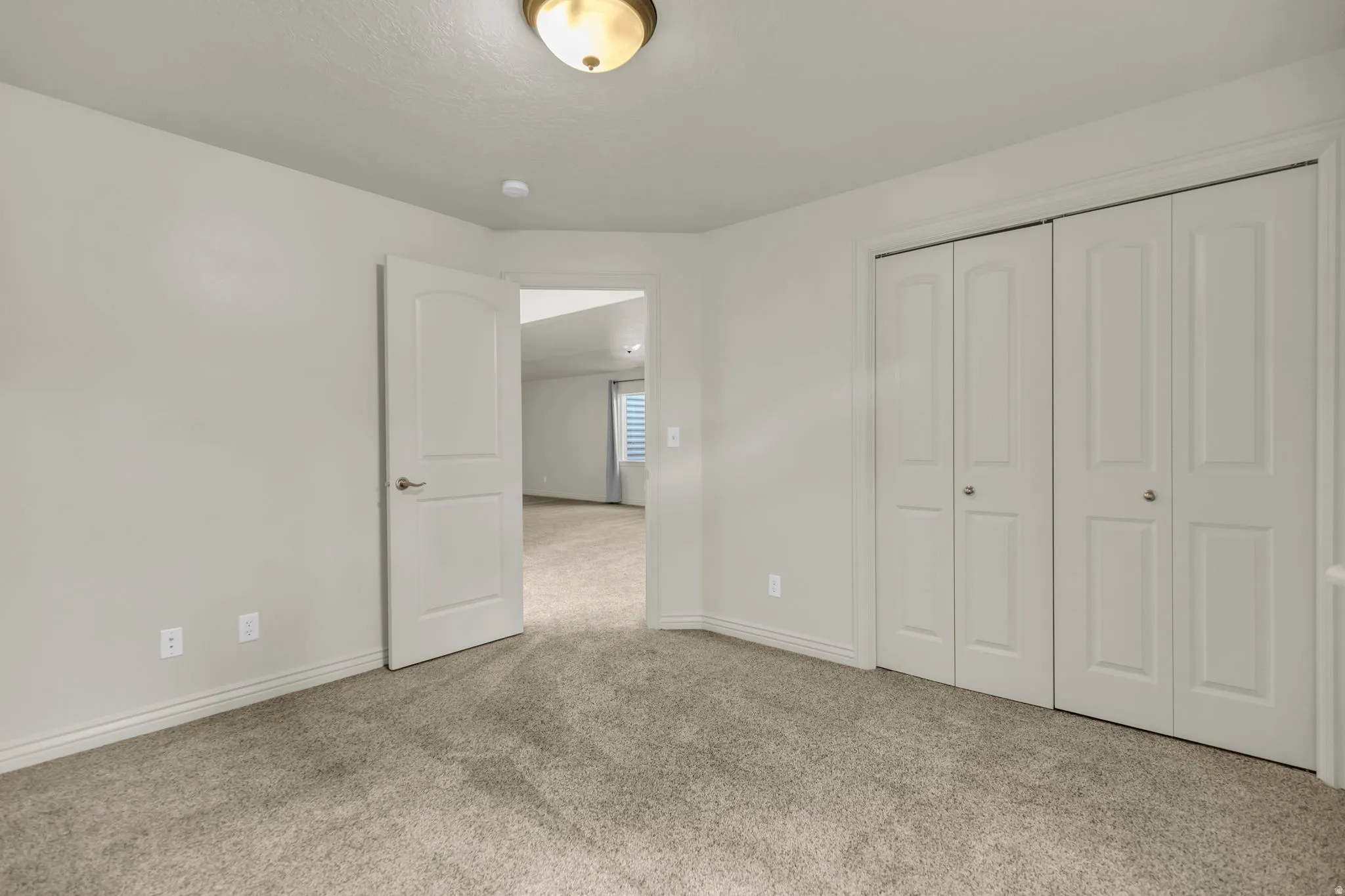 Unfurnished bedroom featuring light colored carpet and a closet