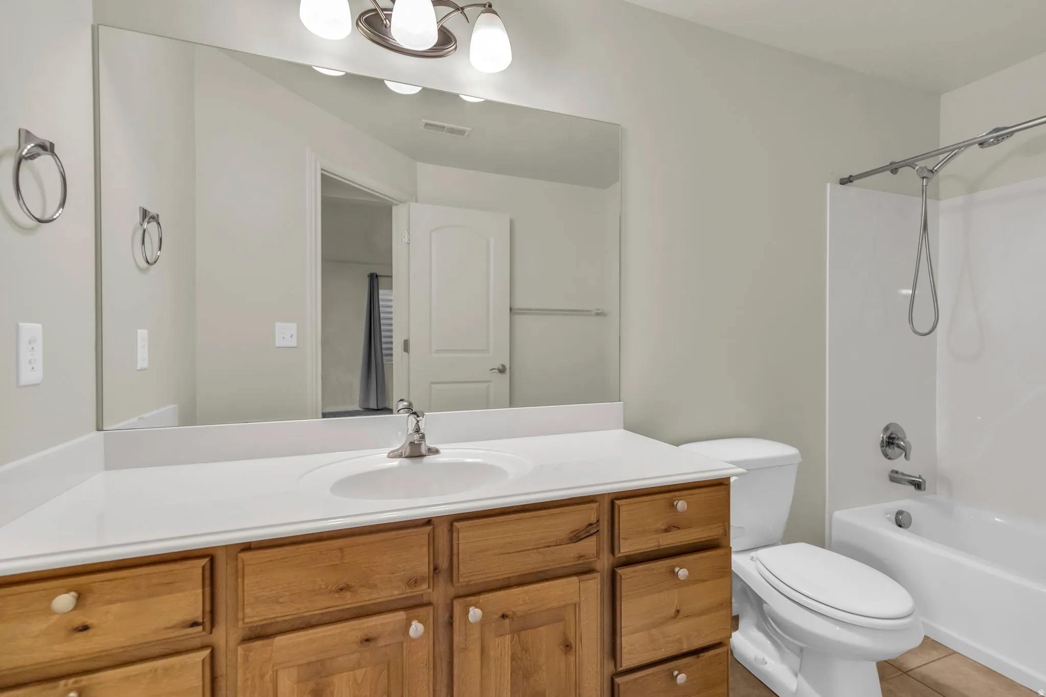 Bathroom featuring vanity, shower / washtub combination, and light tile patterned floors