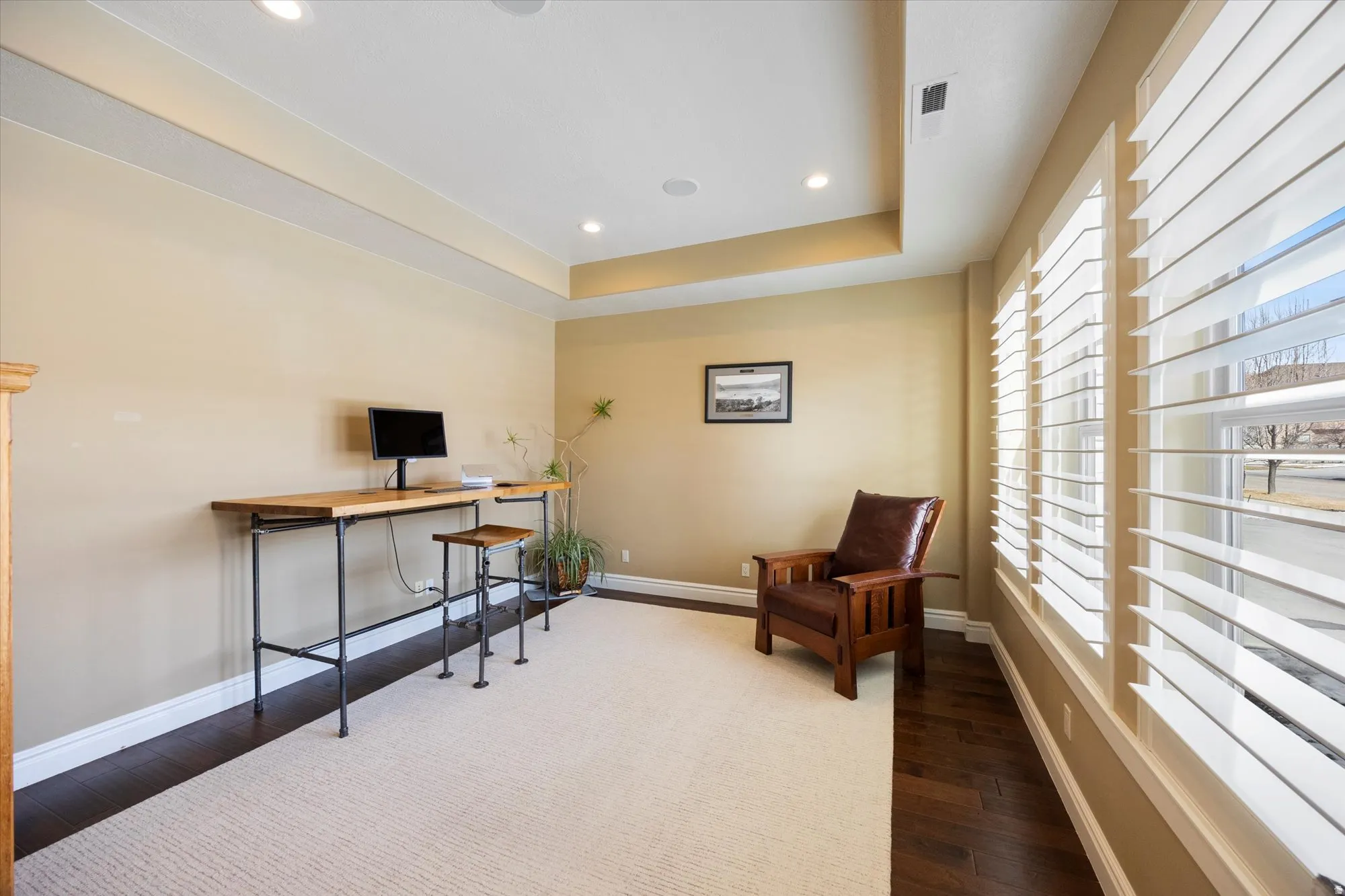 Sitting room featuring recessed lighting, a raised ceiling, dark wood-type flooring, and a desk