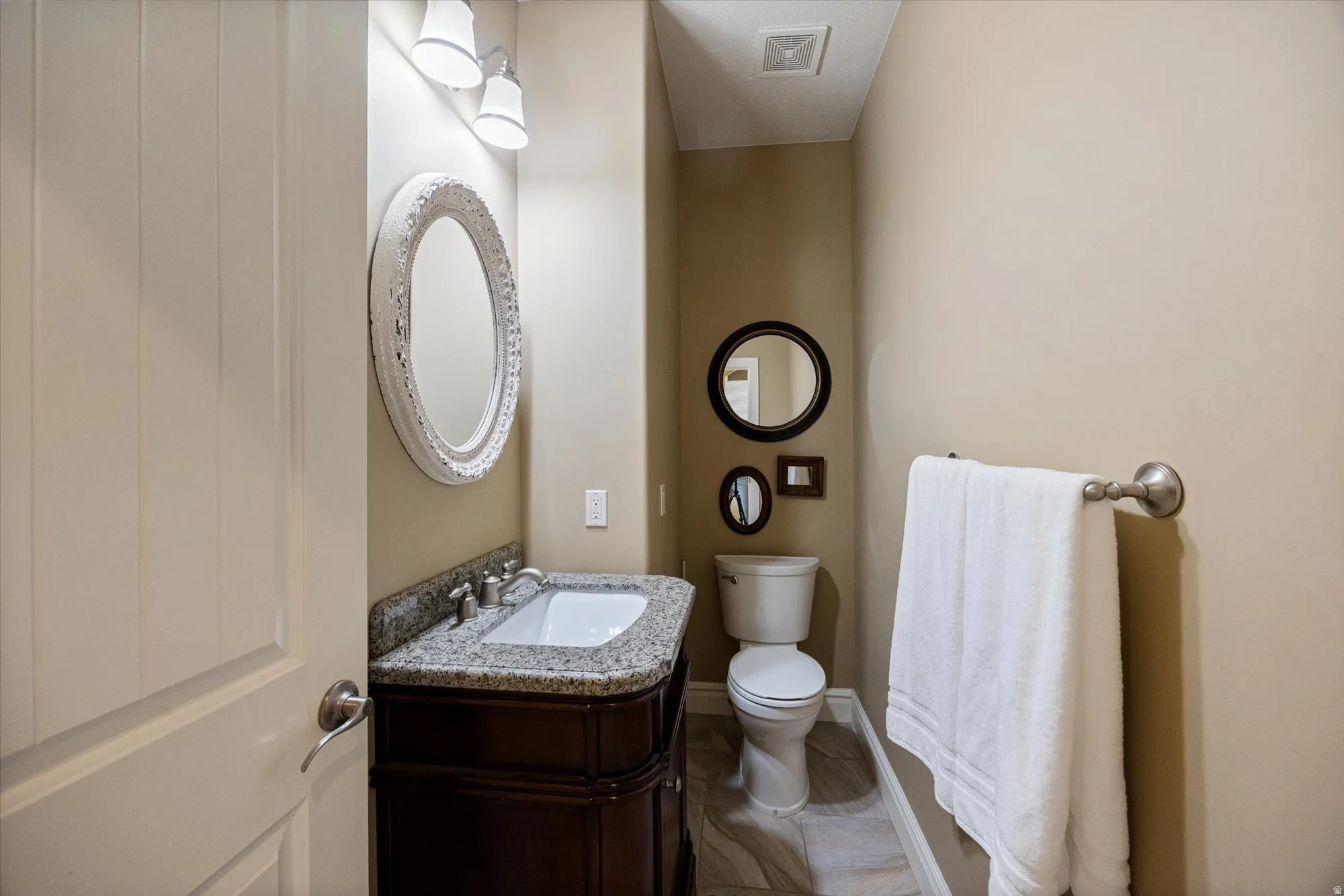 Half bathroom featuring vanity and toilet