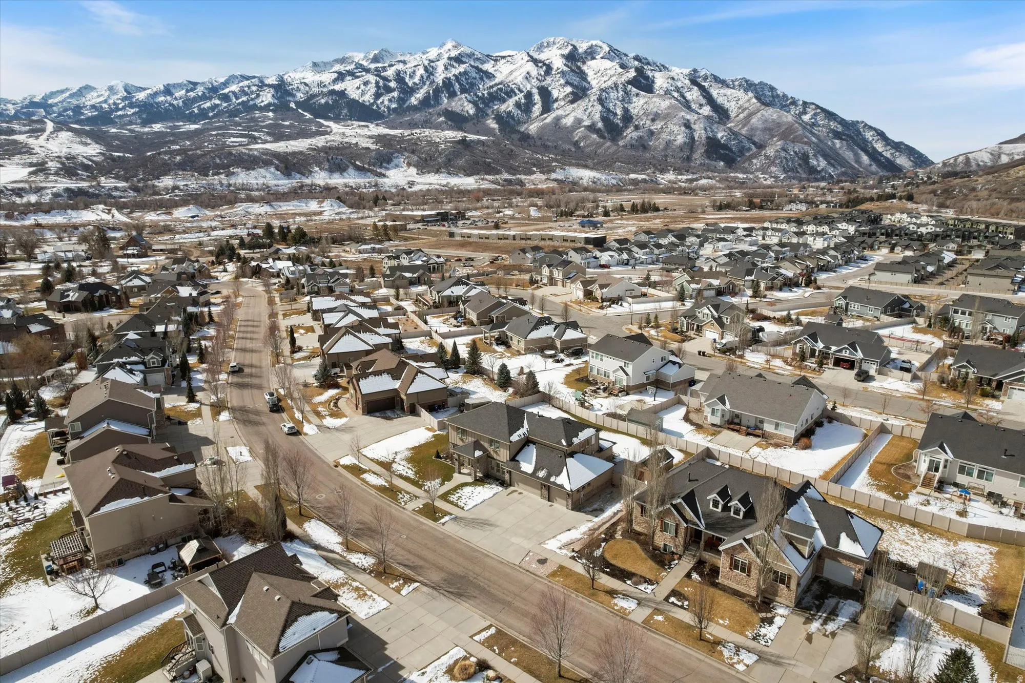 Snowy aerial view featuring a mountain view and a residential view