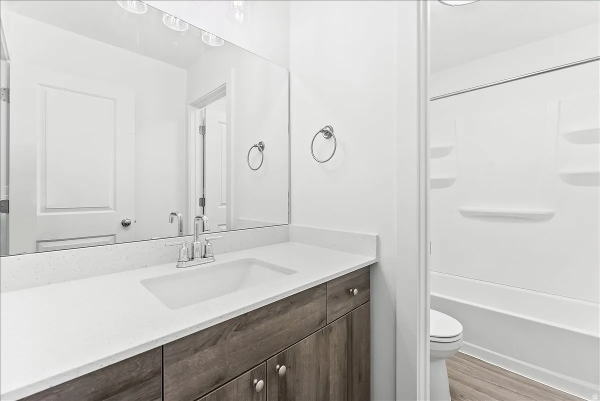 Bathroom featuring vanity, light wood-style floors, and shower / bathtub combination