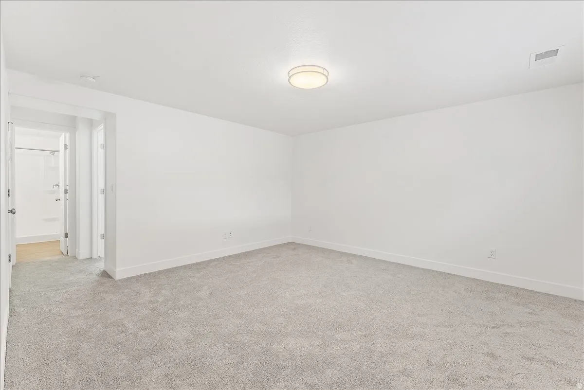 Empty room featuring light colored carpet