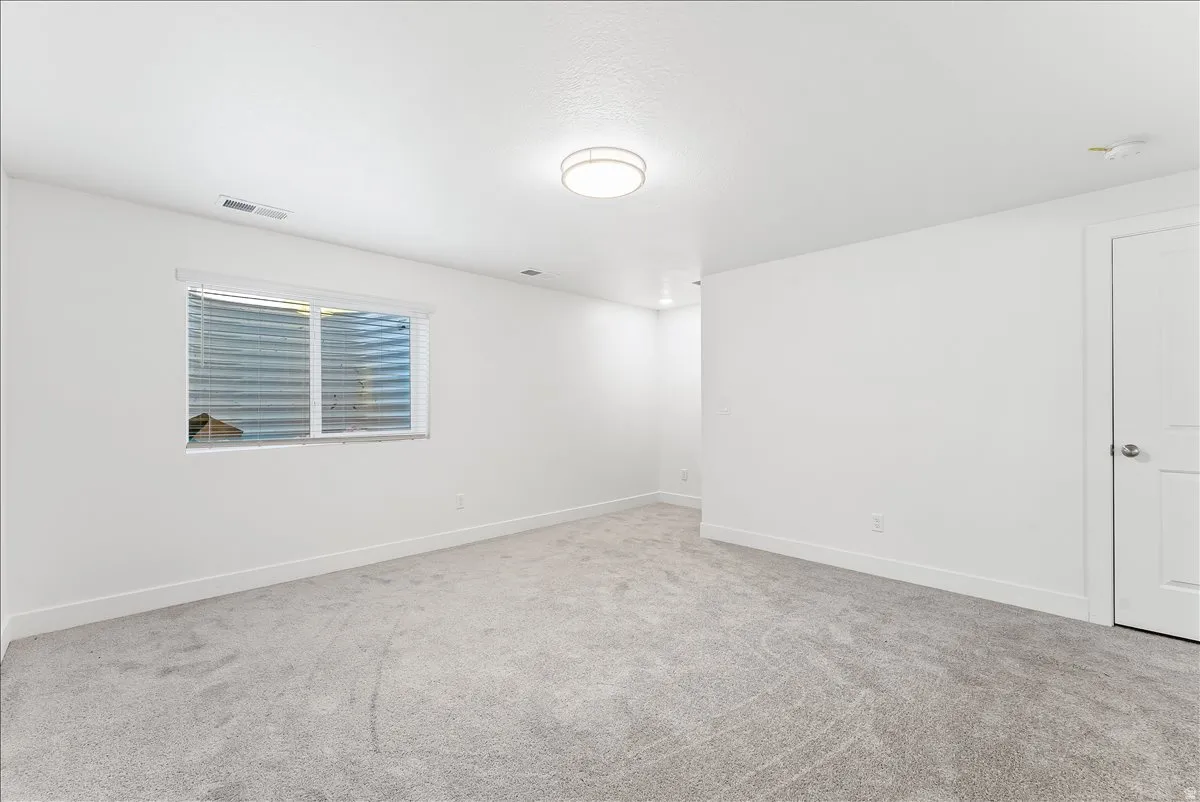Spare room with baseboards and light carpet
