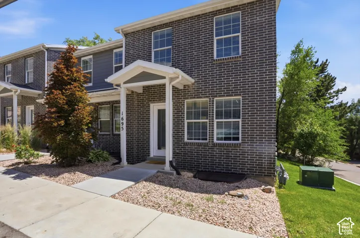 Townhome exterior featuring dark brick and gray siding