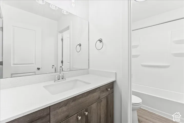 Bathroom featuring vanity, light wood-style floors, and shower / bathtub combination