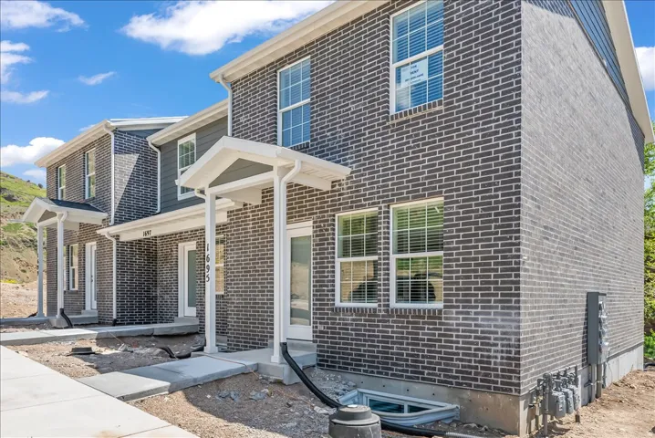 View of front of home featuring brick siding and a porch