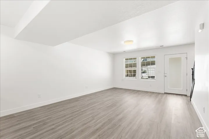 Empty room with light wood-type flooring and baseboards