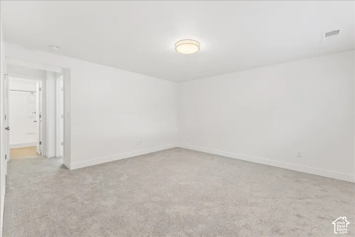 Empty room featuring light colored carpet