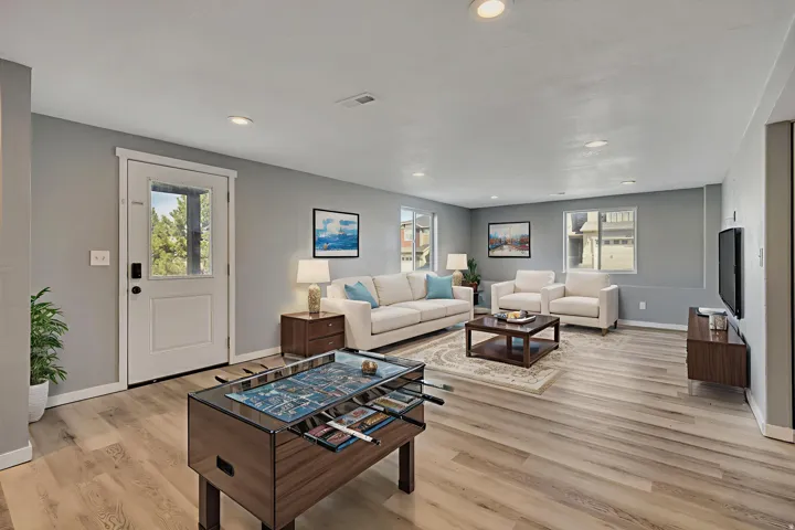 Living area featuring light wood-type flooring, healthy amount of natural light, and recessed lighting