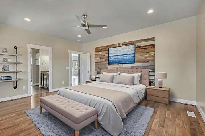 Bedroom with wood finished floors, a ceiling fan, an accent wall, recessed lighting, and wood walls