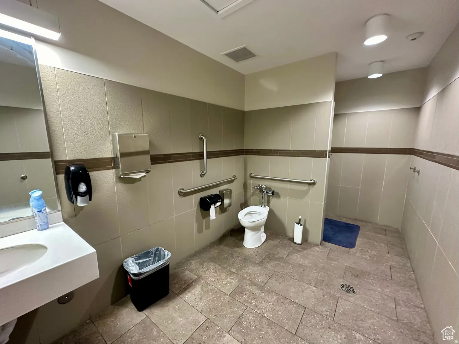 Bathroom featuring tile walls and toilet