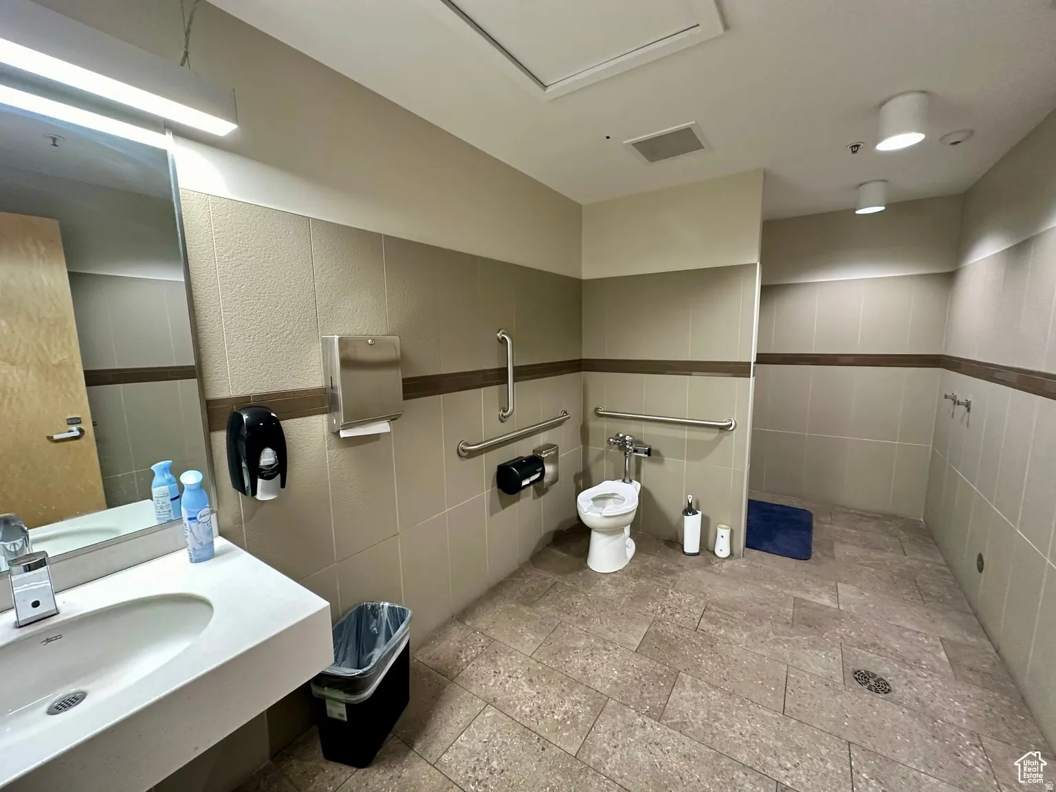 Bathroom featuring tile walls and stone tile floors