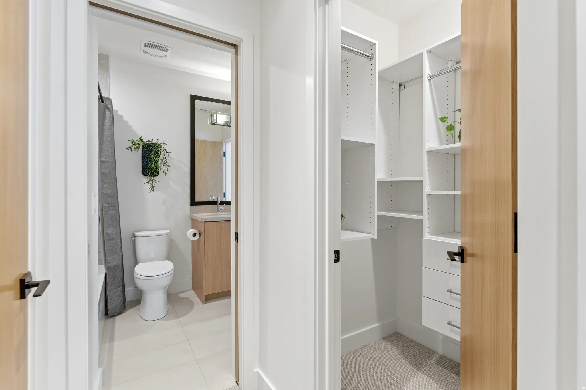 Bathroom featuring vanity, shower / tub combo, and light tile patterned floors
