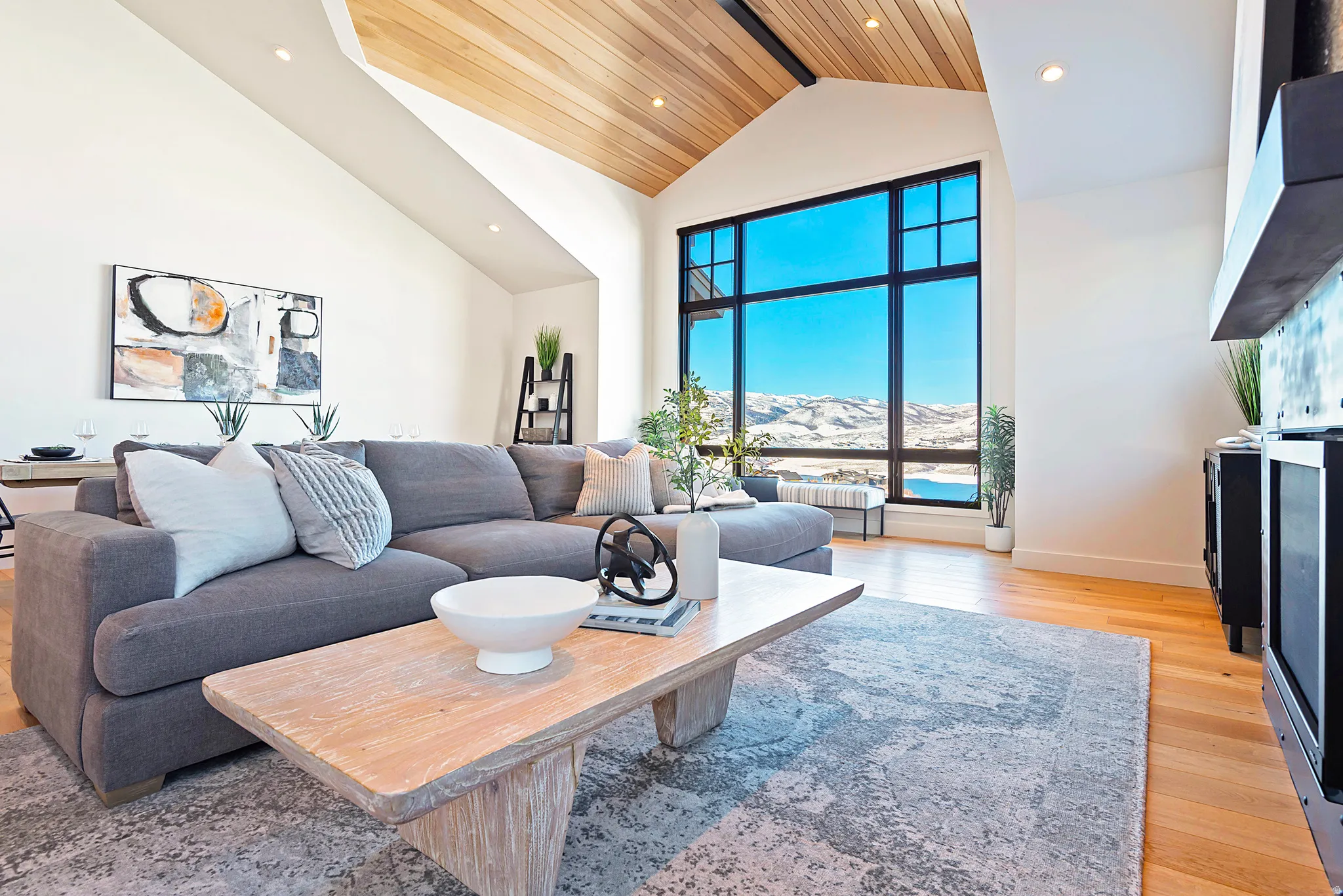 Living area with a high ceiling, light wood-style flooring, recessed lighting, and a mountain view