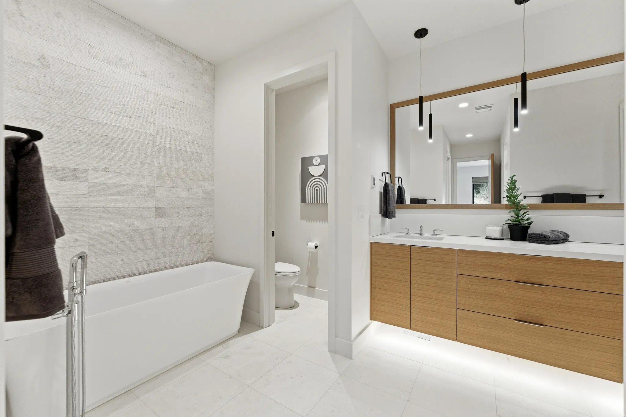 Bathroom featuring vanity, a freestanding tub, and light tile patterned floors