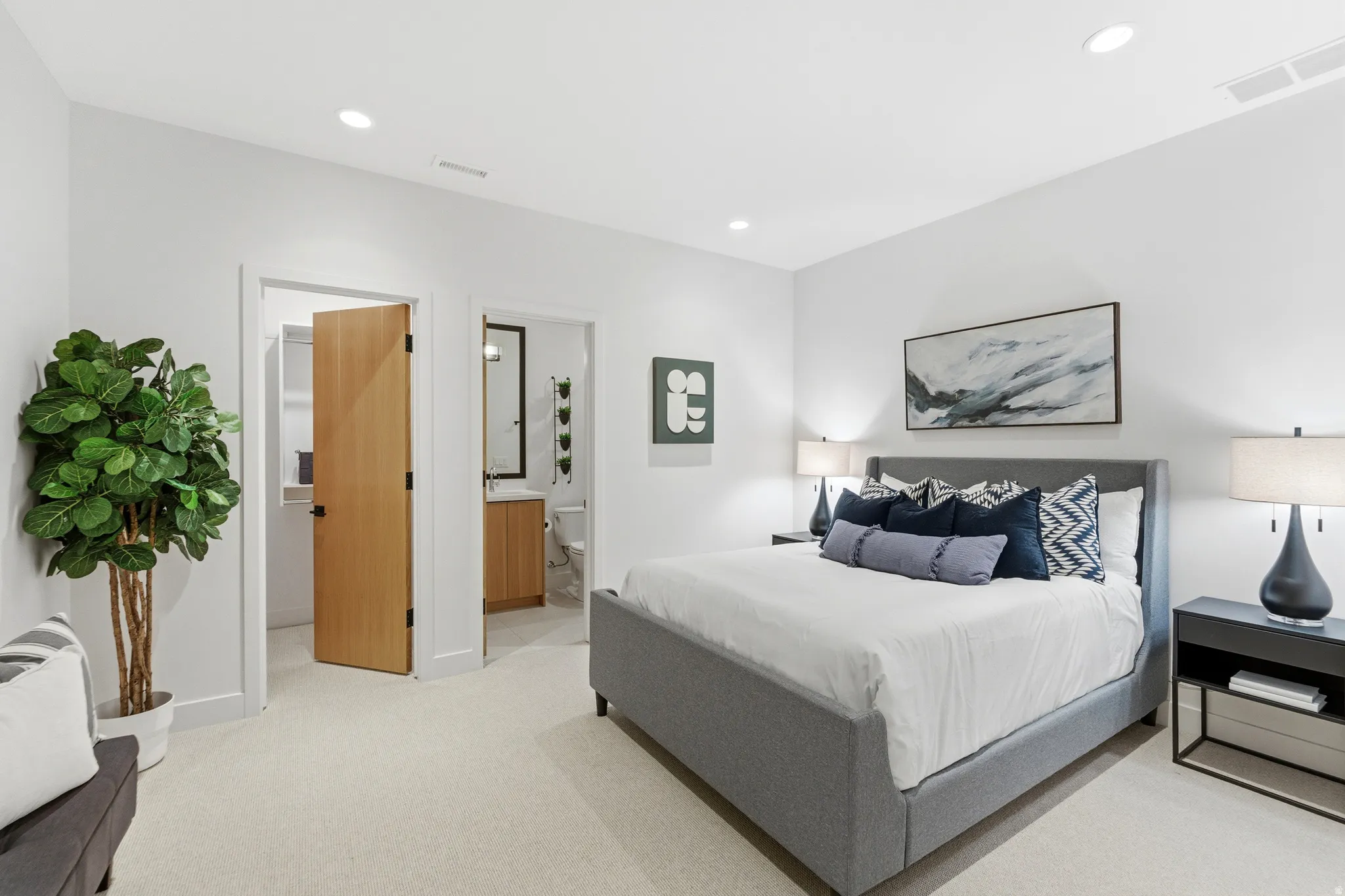 Bedroom featuring light carpet, ensuite bath, and recessed lighting